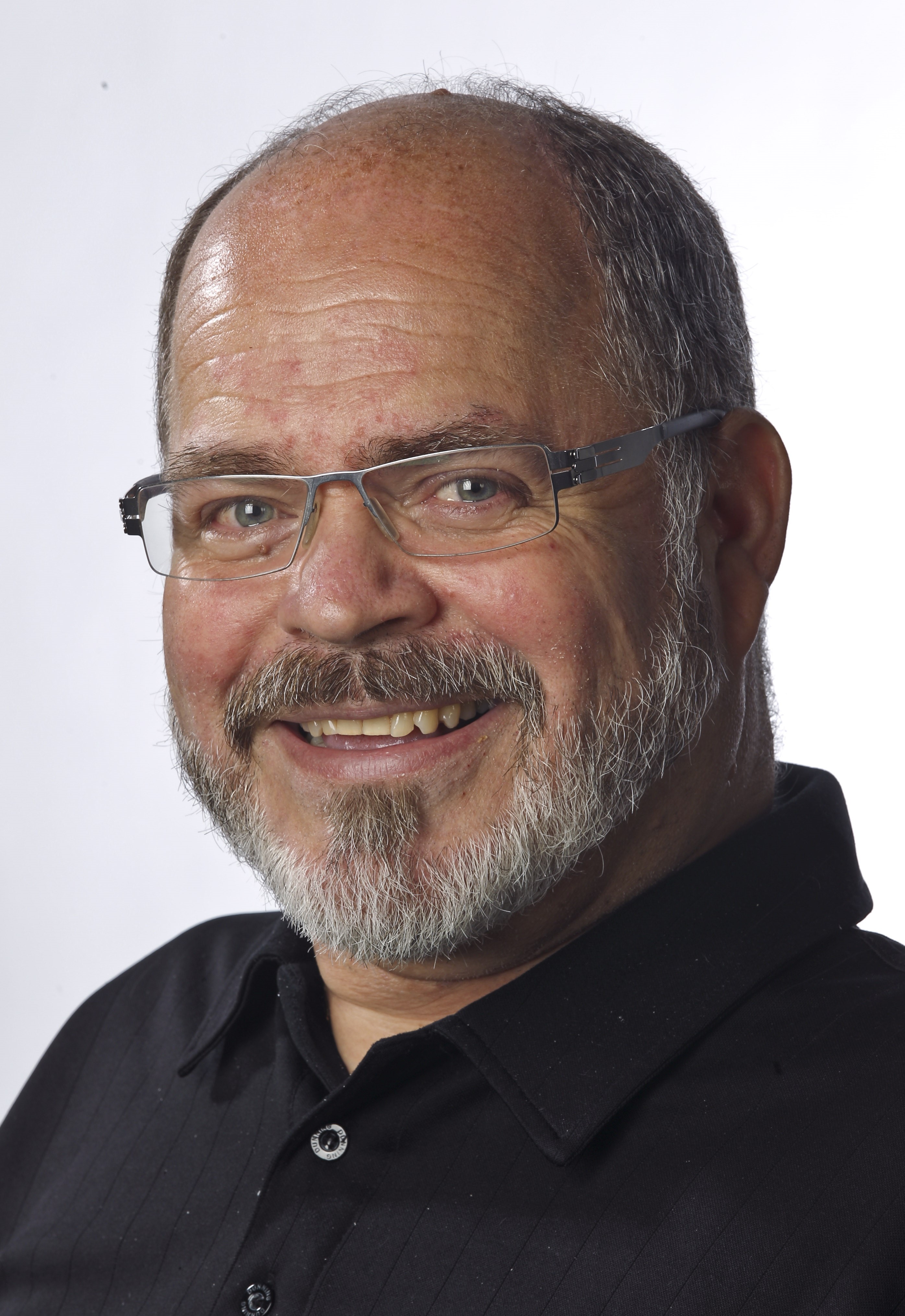 Headshot of Jacques LeBlanc, who has a short grey beard and hair and is wearing glasses and a black collared shirt.